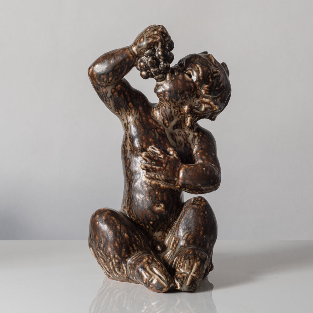 Knud Kyhn for Royal Copenhagen, Denmark, stoneware faun figure eating grapes with Sung glaze