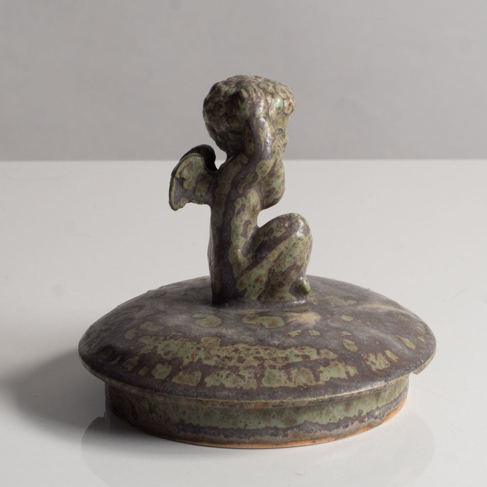 Stoneware lid with figure of cherub with green matte glaze by Arne Bang J1091