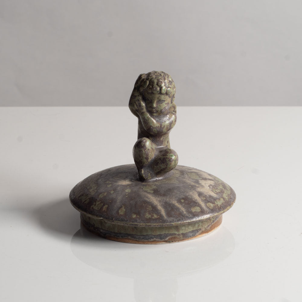 Stoneware lid with figure of cherub with green matte glaze by Arne Bang J1091